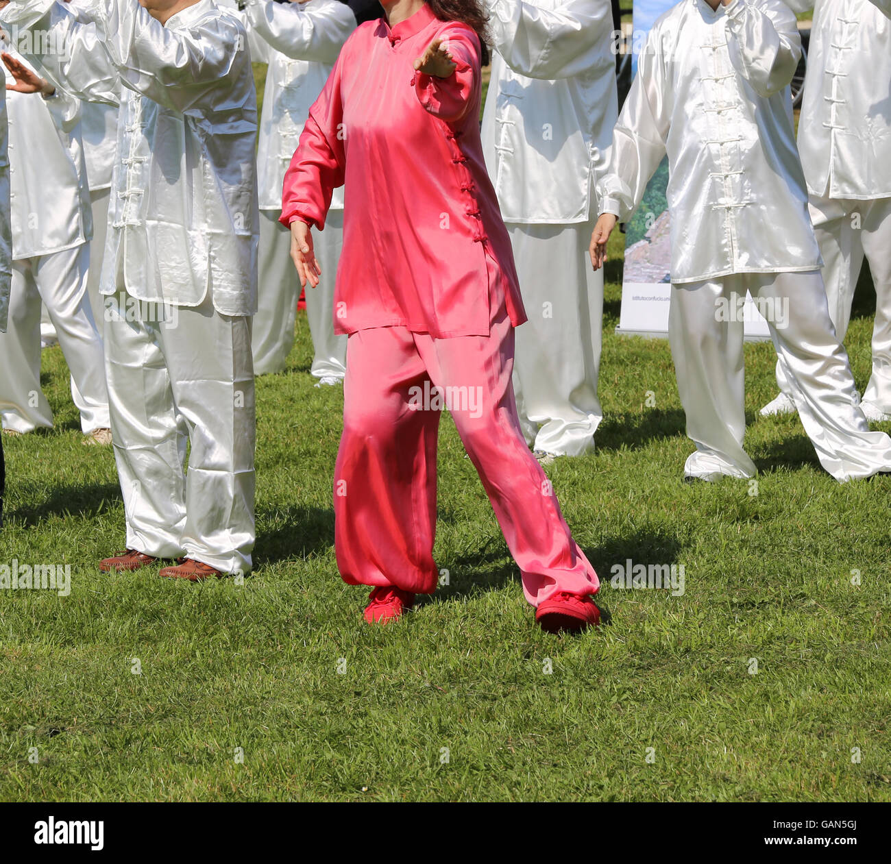 Tai Chi art martial avec femme robe en soie rose parfaitement exécuter les exercices dans le grand parc public Banque D'Images