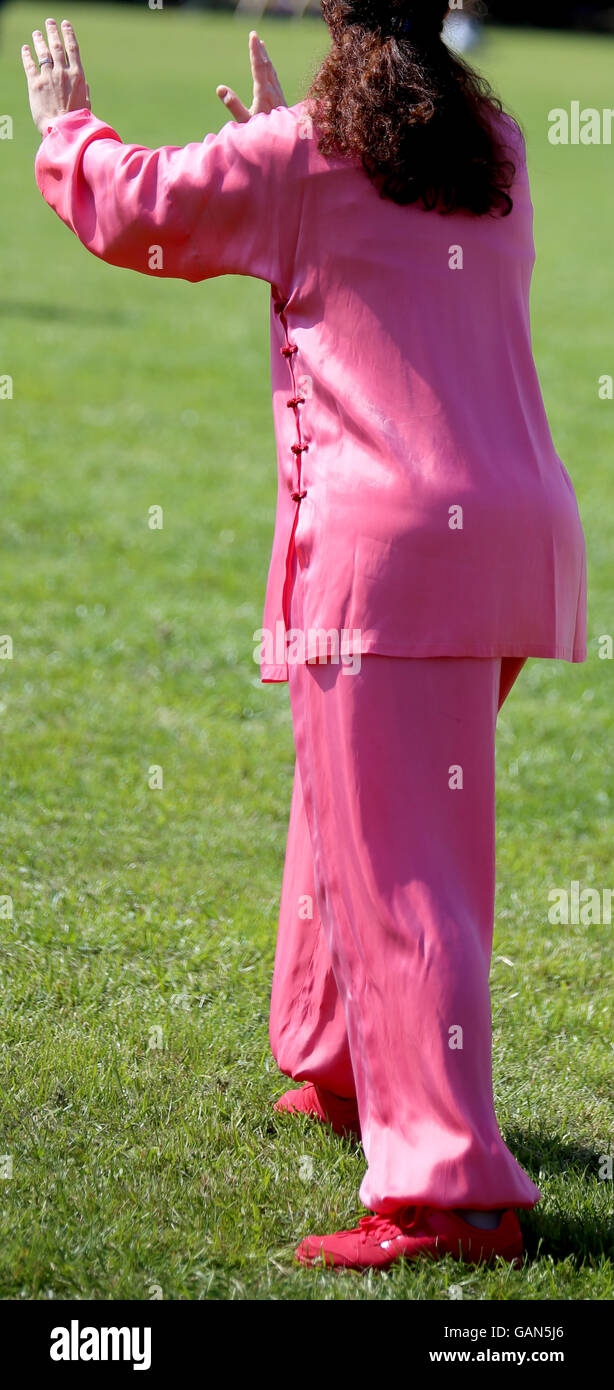 Tai Chi art martial avec femme robe en soie rose parfaitement exécuter les exercices dans le grand parc Banque D'Images