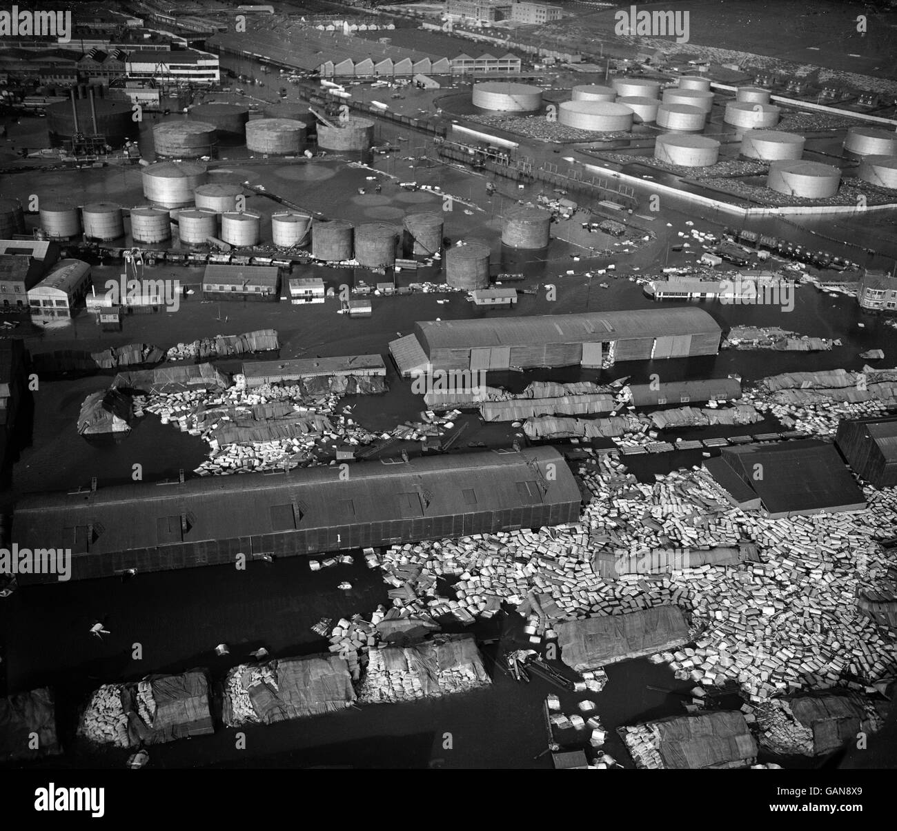 Avec des masses de fûts d'huile tumultés au premier plan, les réservoirs de stockage de pétrole vus debout au milieu des eaux d'inondation dans cette photo aérienne prise dans la région de Tilbury. La région de l'estuaire de la Tamise a souffert des inondations désastreuses qui ont dévasté les côtes est et sud-est de la Grande-Bretagne. Banque D'Images