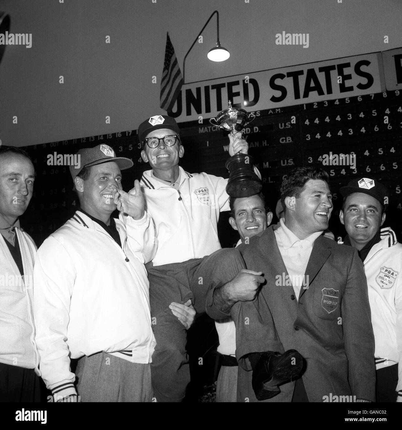 Jerry Barber, le capitaine de l'équipe américaine de la Ryder Cup, qui a remporté le prix, se retrouve élevé par les autres membres de son équipe après avoir reçu le trophée convoité de Lord Brabazon de Tara, président de la British Professional Golfers Association. Banque D'Images