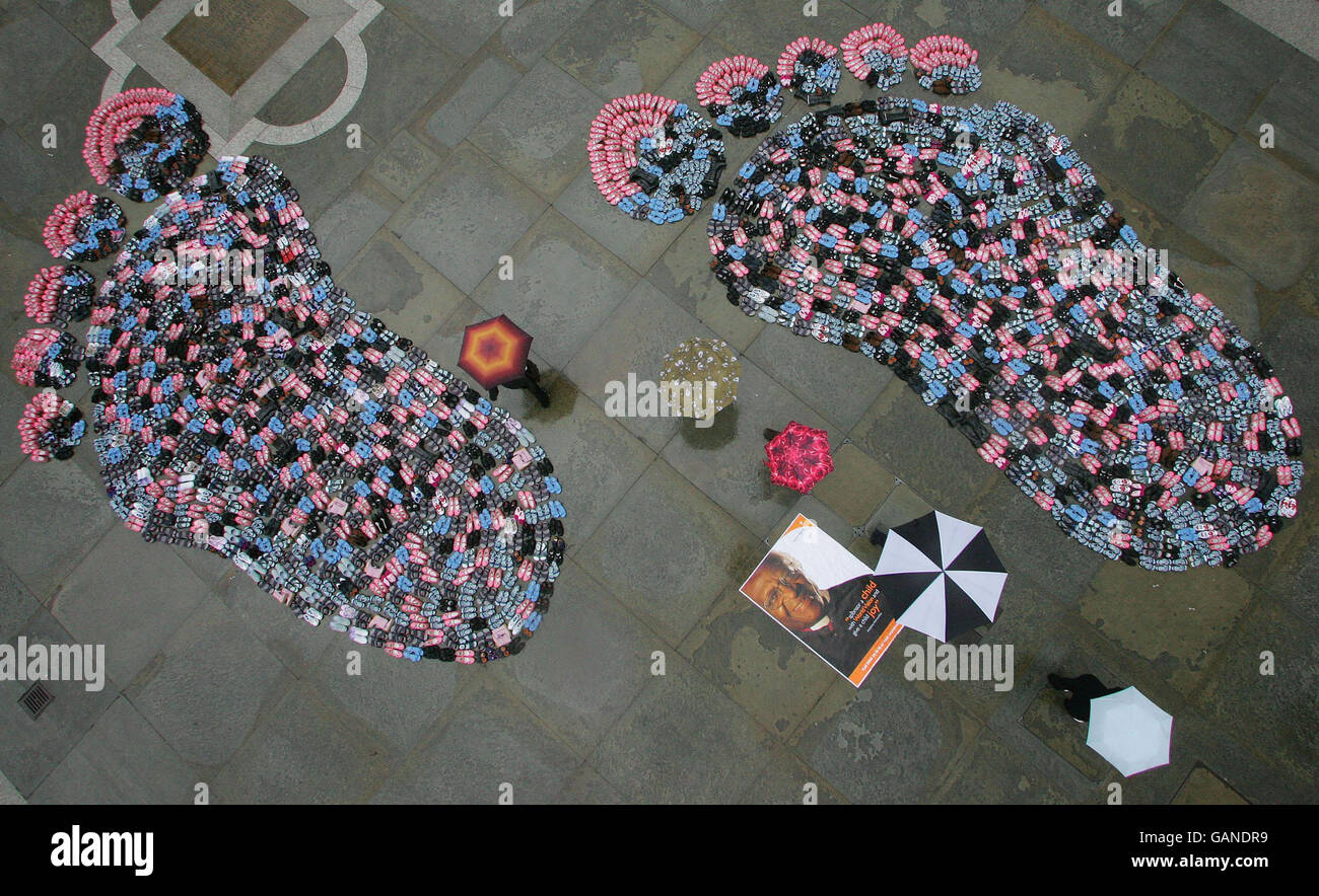 Des milliers de chaussures, chacune représentant un enfant qui a désespérément besoin de parrainage dans le monde en développement, forment aujourd'hui une paire de pieds géants dans Trafalgar Square à Londres pour lancer la campagne de parrainage d'enfant de Vision mondiale. Banque D'Images