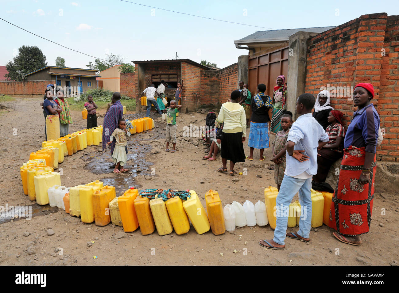 Une longue ligne de colis en attente d'être comblé à un point d'eau public à Ruhengeri, Rwanda, Afrique du Sud Banque D'Images