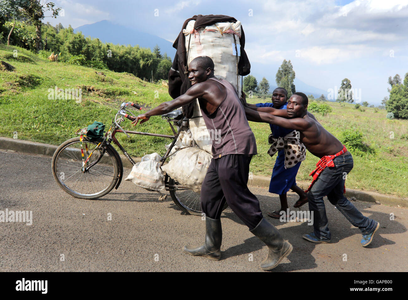 Les gens poussant location de taxis pour charge lourde près de Ruhengeri, Rwanda, Afrique du Sud Banque D'Images