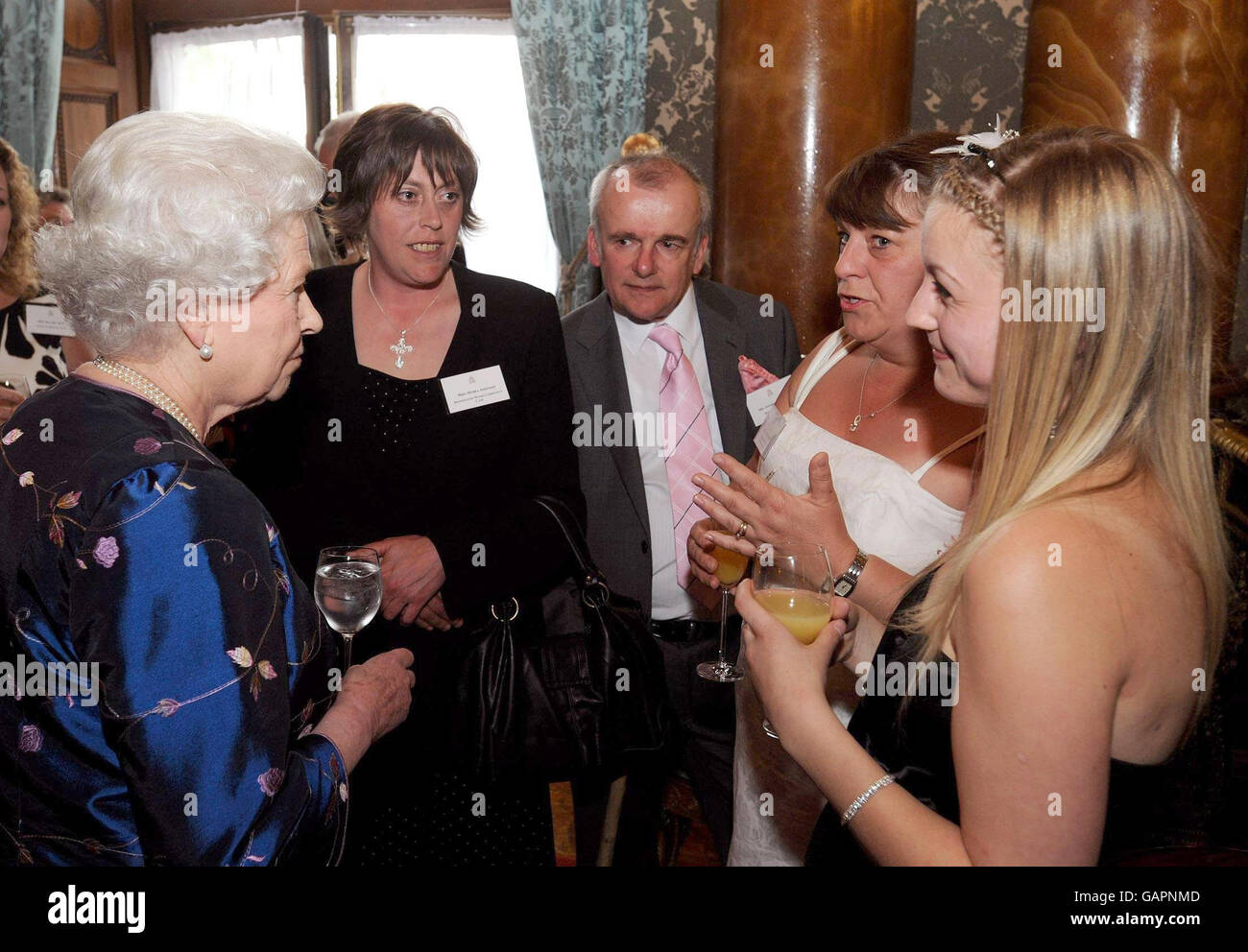 La reine Elizabeth II de Grande-Bretagne s'entretient avec Jill Coleman (deuxième à droite) et Leanne Coleman (droite) du projet Amazone Young Women's au Queen's Award pour le service volontaire au Palais de Buckingham, à Londres. Banque D'Images