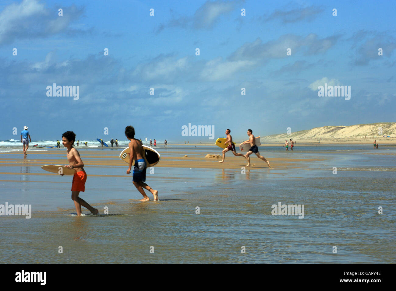 Les garçons et les jeunes hommes à faire leur chemin à l'Atlantique surf, Cap Ferret, Sud Ouest France. Banque D'Images