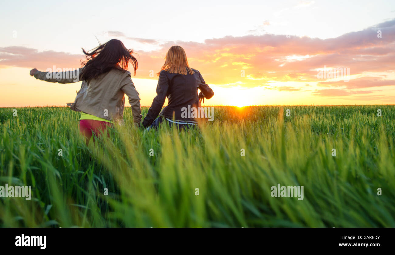 Blonde girl kissing et son joli sourire meilleurs amis à l'extérieur. Banque D'Images