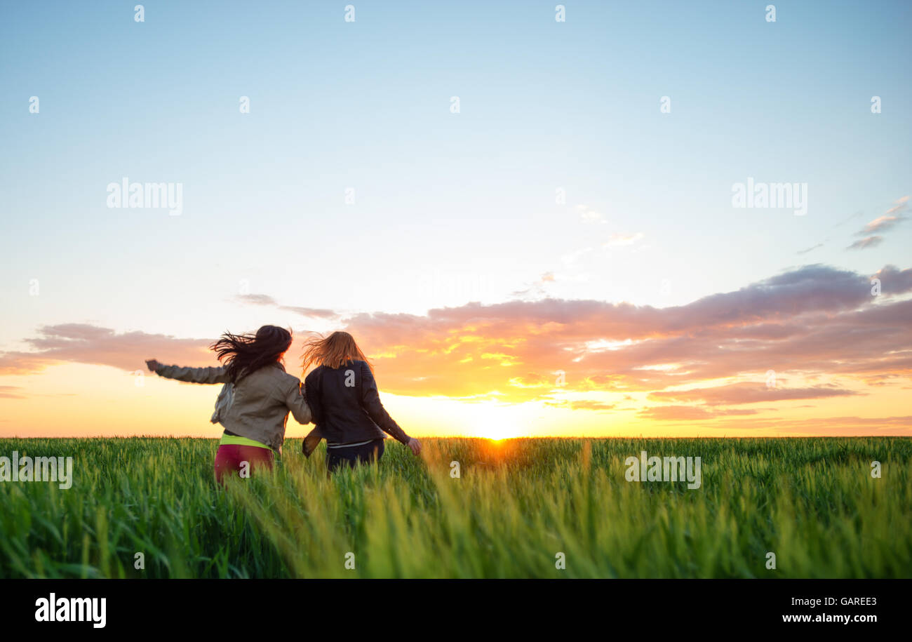 Deux amies d'exécution en blé pour le coucher du soleil Banque D'Images