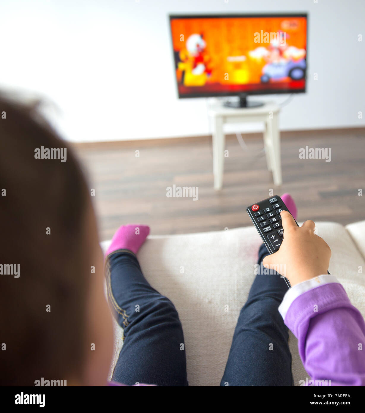 Petit enfant de regarder la télévision dans le salon Banque D'Images