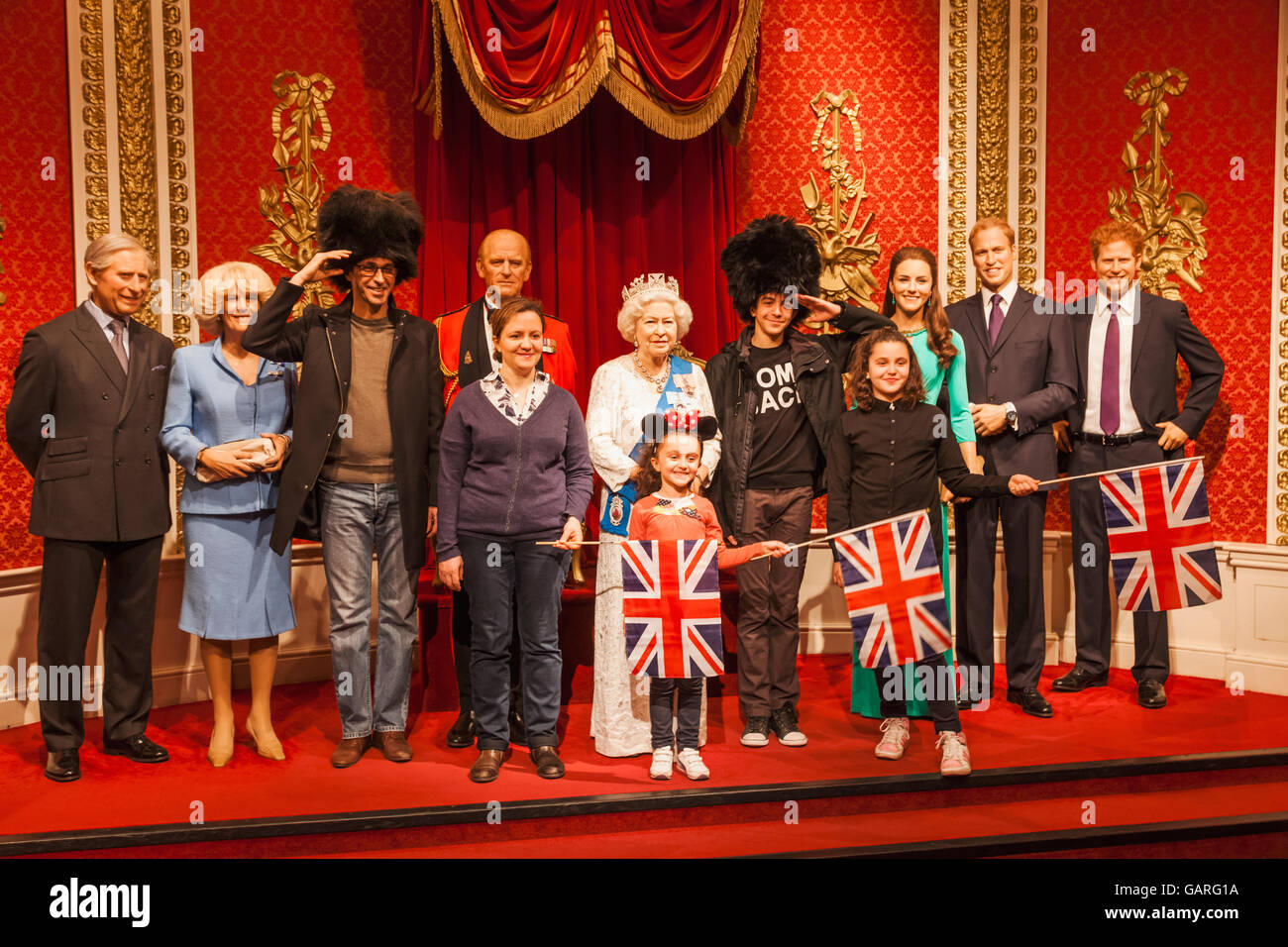 L'Angleterre, Londres, Madame Tussauds, touristes posant avec figures de cire de la Reine et la Famille royale Banque D'Images