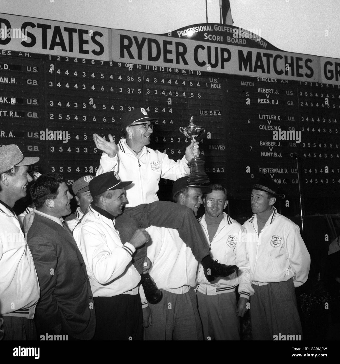 Jerry Barber, le capitaine de l'équipe américaine de la Ryder Cup, qui a remporté le prix, se retrouve élevé par les autres membres de son équipe après avoir reçu le trophée convoité de Lord Brabazon de Tara, président de la British Professional Golfers Association. Banque D'Images