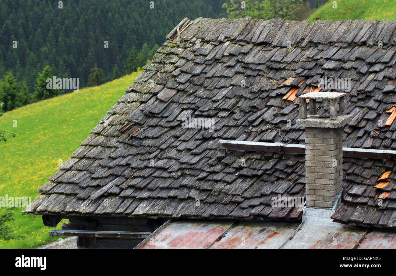 Toit de bardeaux de bois et cheminée en pierre Banque D'Images