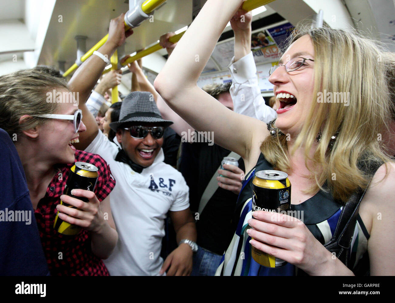 Les fêtards boivent sur un train tube Circle Line, avant que l'interdiction de boire de l'alcool n'entre en vigueur à minuit. Banque D'Images