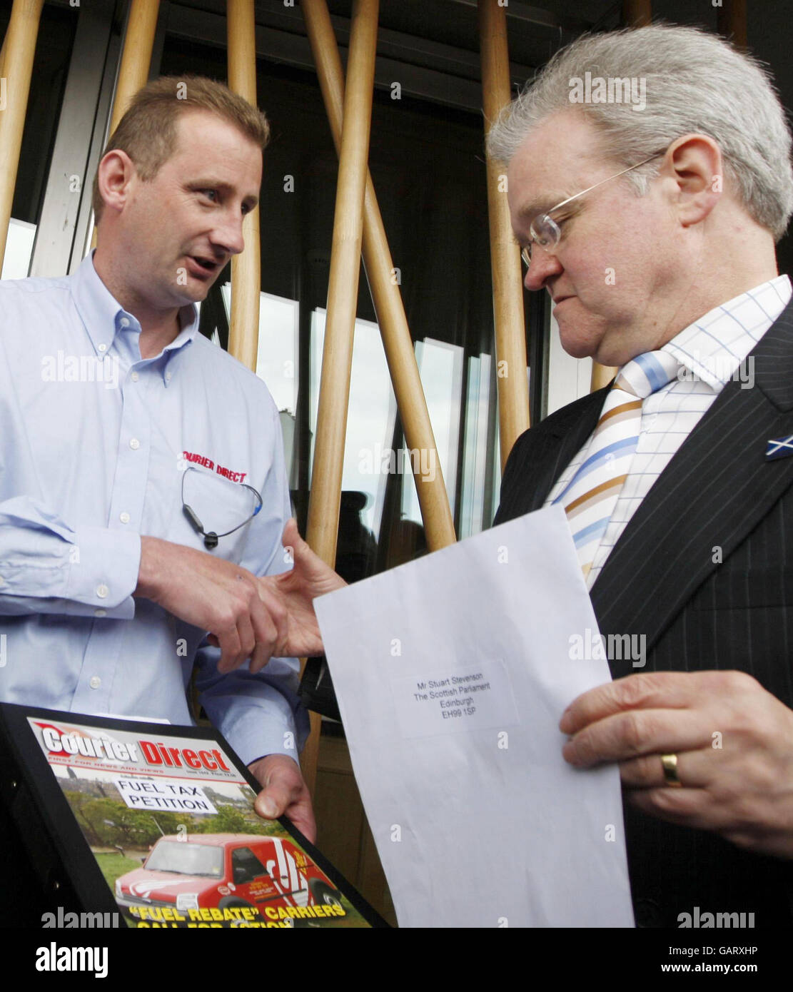 Le chauffeur de camion Brian Regan (à gauche) remet une lettre au ministre des Transports Stewart Stevenson pour protester contre la hausse du coût du carburant à l'extérieur du Parlement écossais, à Édimbourg. Banque D'Images