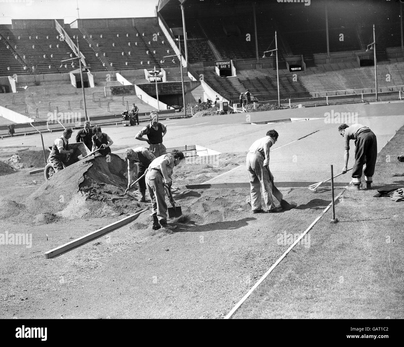 Les travailleurs préparent la longue piste de saut à l'intérieur du stade Wembley Banque D'Images