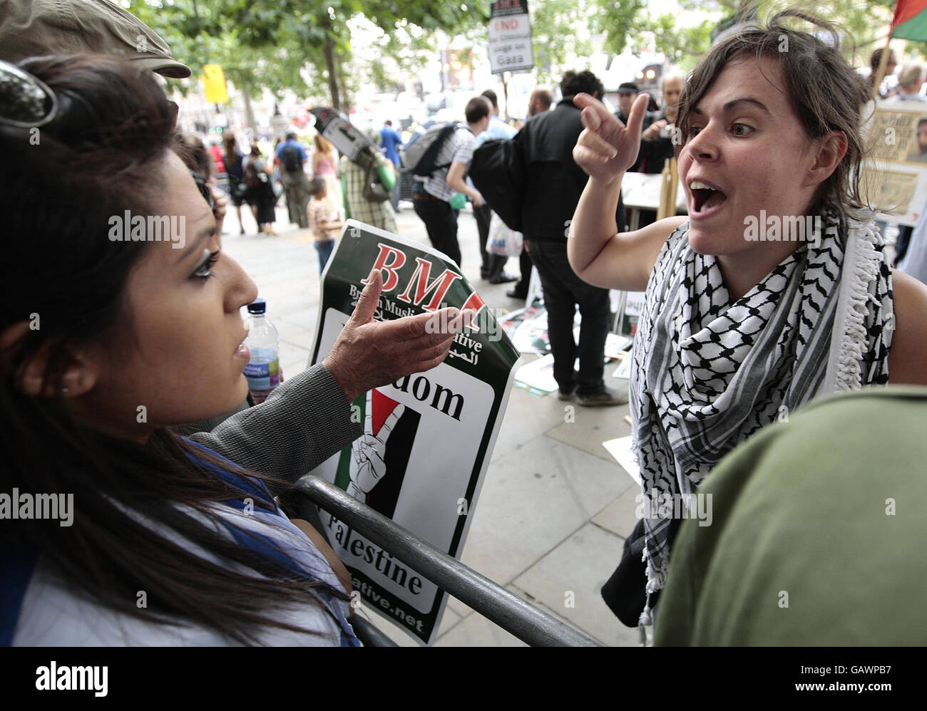Un manifestant pro-palestinien (à droite) plaide auprès d'une femme juive (à gauche) lors d'une manifestation coïncidant avec la parade de Salute to Israel à Trafalgar Square, Londres, Royaume-Uni. Banque D'Images
