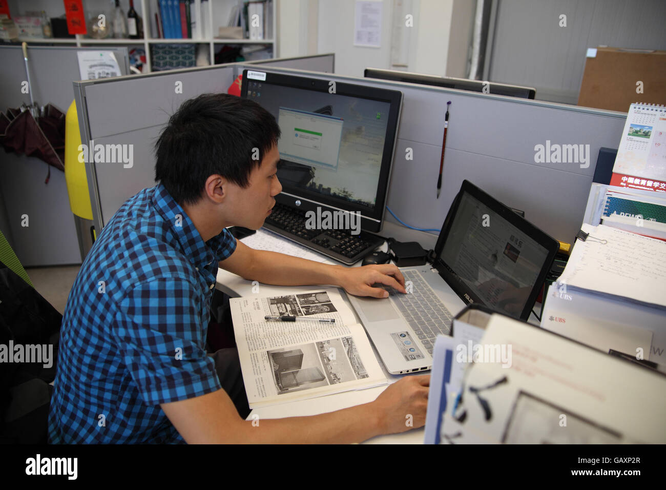 Un jeune homme est étudiant à l'aide de son ordinateur portable pour concevoir quelque chose de la fonction Design Lab à l'Université polytechnique de Hong Kong. Wan Chai, Hong Kong. Banque D'Images
