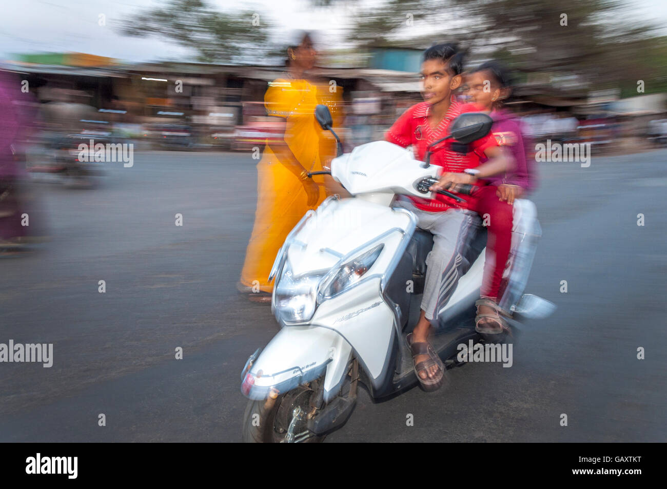 Jeune couple sur cyclomoteur dans Paud village près de Pune, Maharashtra, Inde. Motion Blur Flash. Banque D'Images
