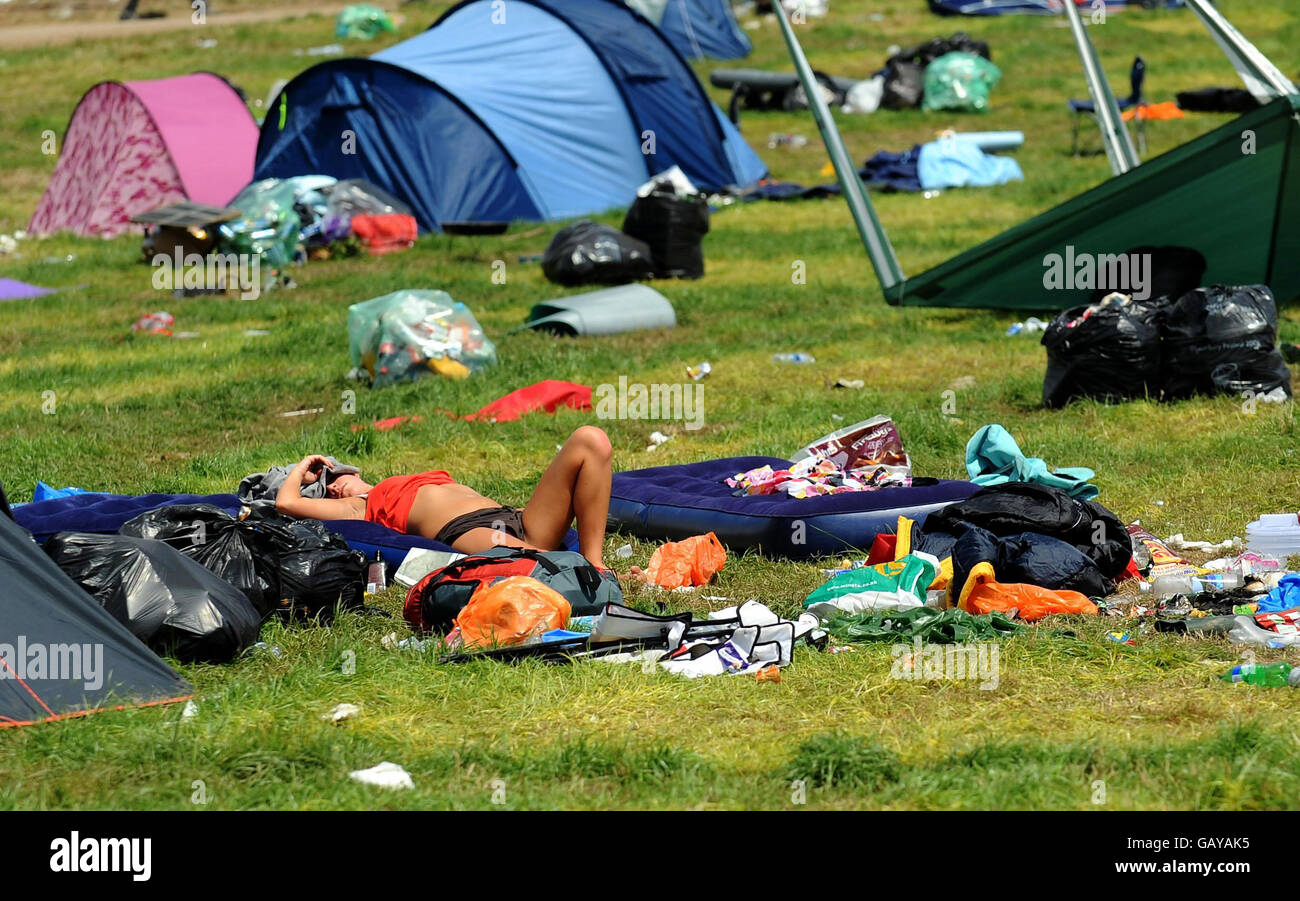 Une fille fait du soleil pendant que les festivaliers quittent la ferme digne après le festival Glastonbury de 2008, dans le Somerset. Banque D'Images