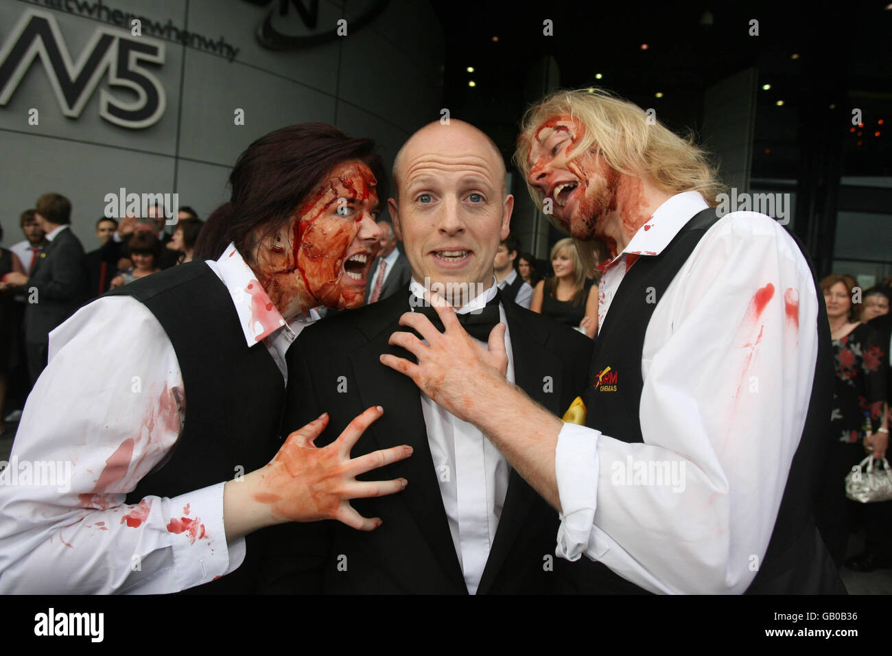 Le réalisateur George Clarke est attaqué par les zombies Claire Douglas et Johnny Burmside lors de la première du premier film d'horreur zombie d'Irlande du Nord, « The Battle of the Bone », à l'Odyssey Arena de Belfast. Banque D'Images