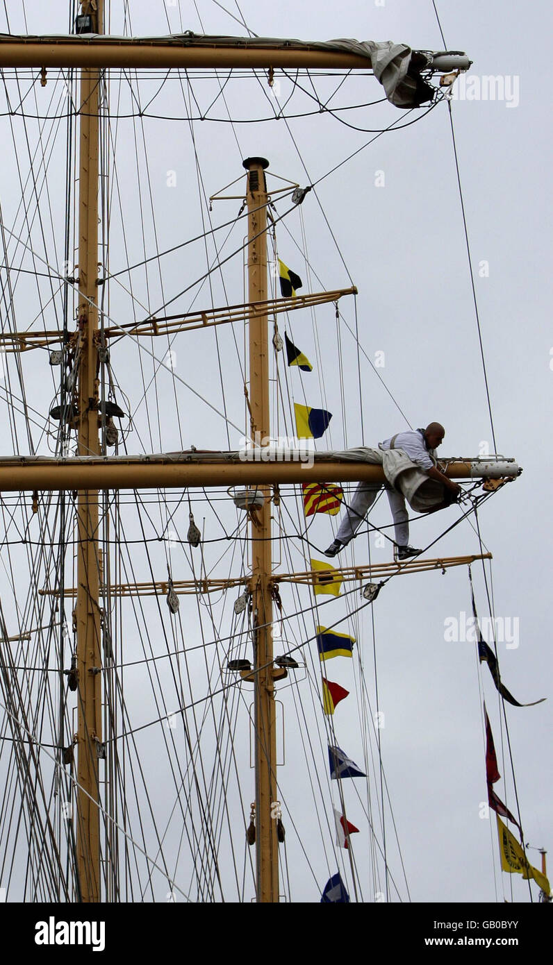 Les marins enveloppent les voiles sur un navire amarré dans l'Albert Dock qui se prépare à participer au Tall Ships Race Festival à Liverpool. Banque D'Images