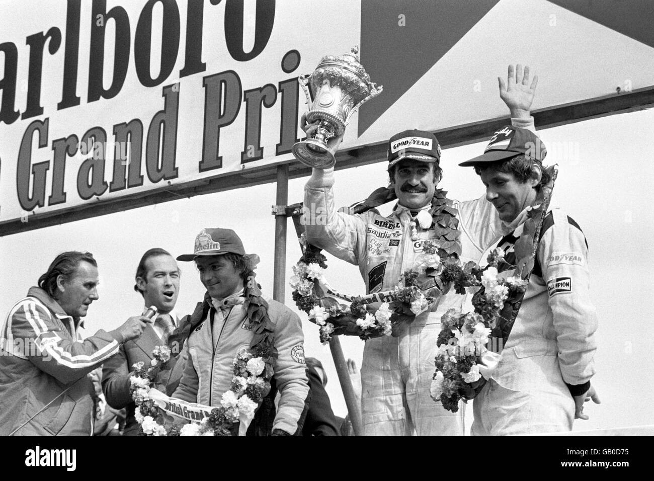 Clay Regazoni, 39 ans, célèbre sur le podium après avoir remporté le Grand Prix britannique de Silverstone. La victoire est également importante parce qu'il a donné à Saudia-Williams leur première victoire au Grand Prix. À sa gauche se trouve la deuxième place, le finisseur René Arnoux, Renault et à droite, Jean-Pierre Jarier, Candy Tyrrell Banque D'Images