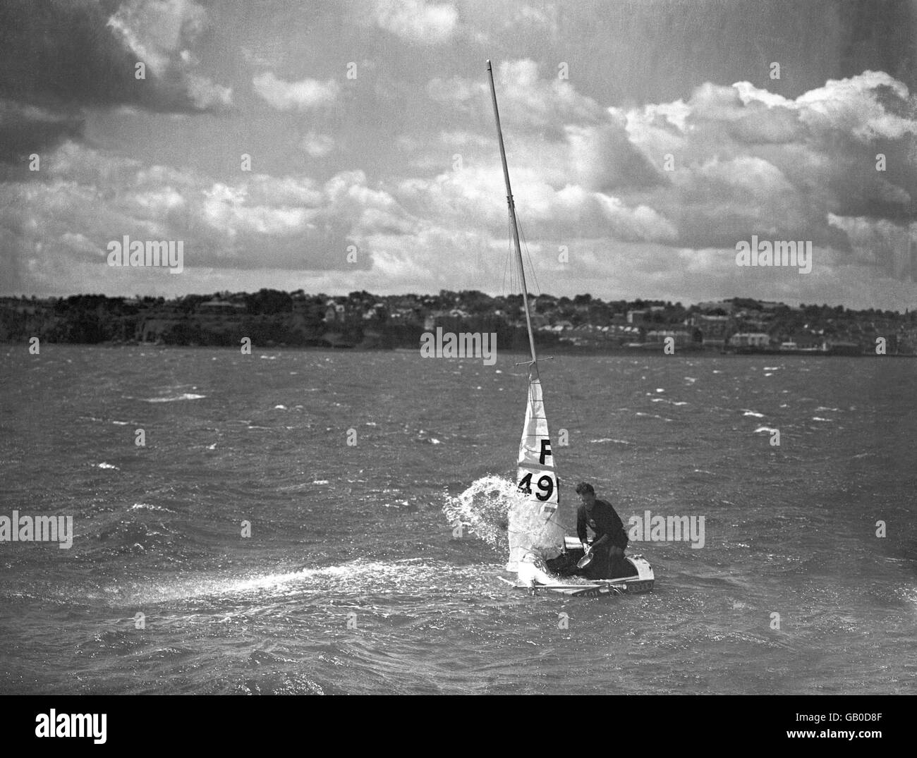 Un bateau semble être en difficulté lors d'un événement de classe Firefly et son timonier tente de vider son bateau d'eau. Banque D'Images