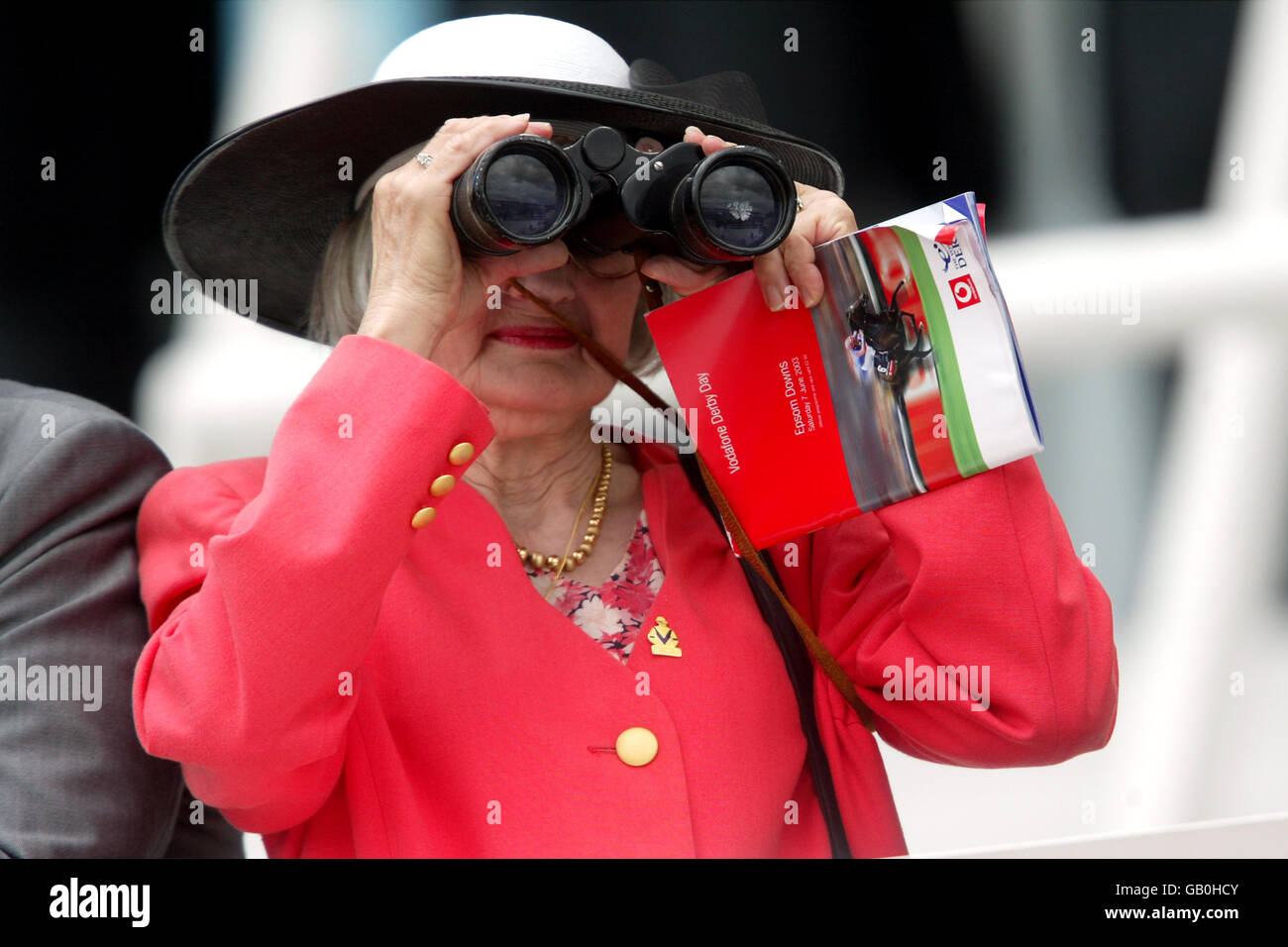 Un Spectator regarde l'action à travers ses jumelles Banque D'Images