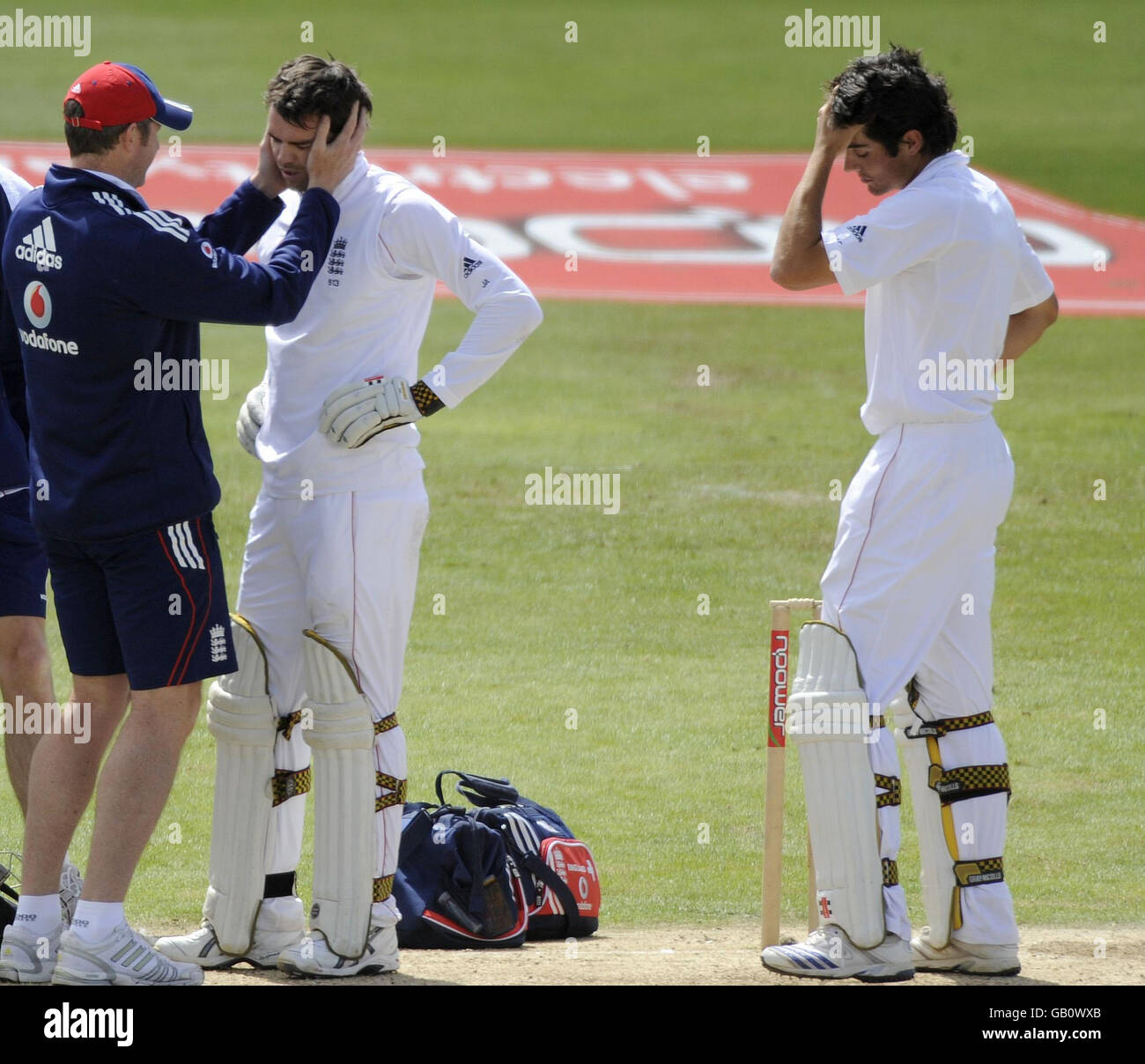 Le batteur d'Angleterre James Anderson reçoit un traitement alors qu'il est surveillé par son partenaire de baseball Alastair Cook (à droite) après avoir été frappé à la tête d'une balle au large de l'Bowler sud-africain Dale Steyn lors du deuxième match de npower Test au terrain de cricket de Headingley, à Leeds. Banque D'Images