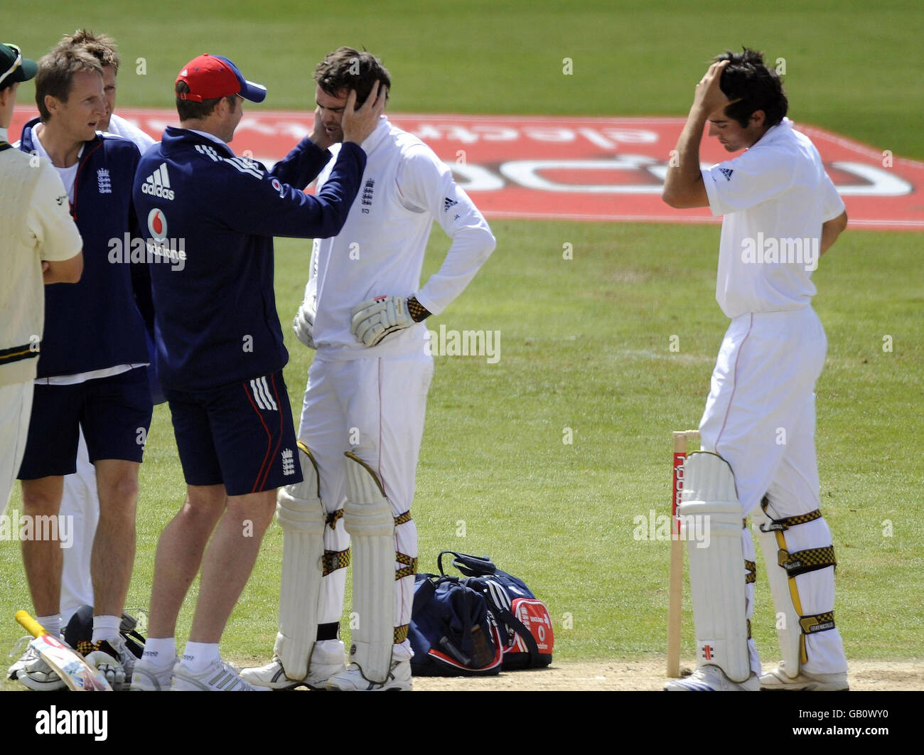Le batteur d'Angleterre James Anderson reçoit un traitement alors qu'il est surveillé par son partenaire de baseball Alastair Cook (à droite) après avoir été frappé à la tête d'une balle au large de l'Bowler sud-africain Dale Steyn lors du deuxième match de npower Test au terrain de cricket de Headingley, à Leeds. Banque D'Images