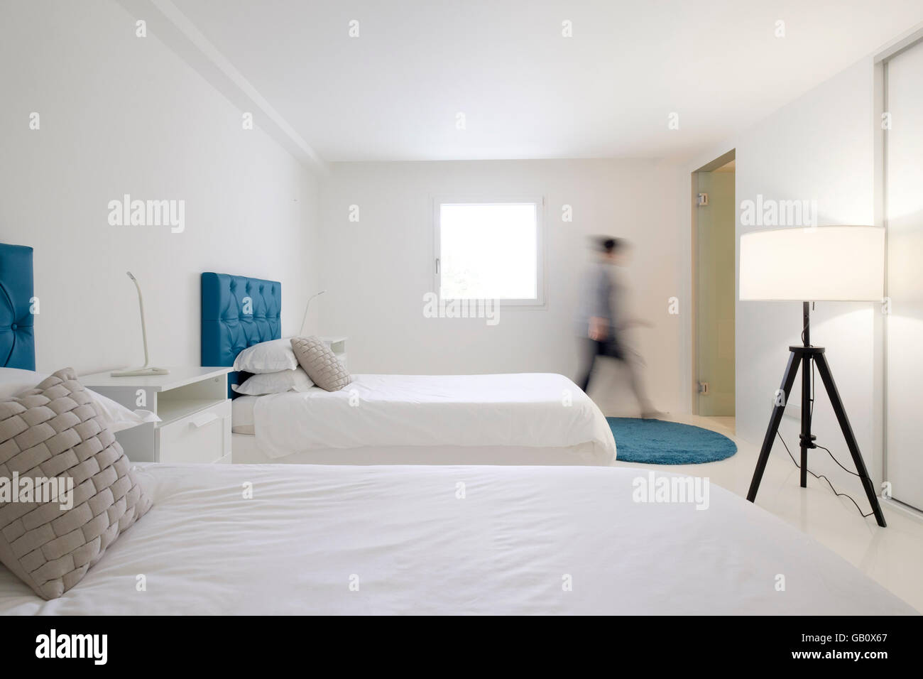Mouvement personne floue marchant dans la chambre d'hôtel avec lits jumeaux Banque D'Images