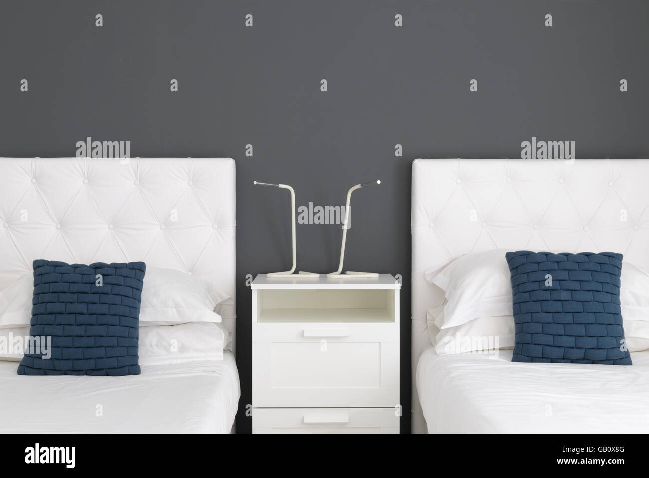 Deux lits simples avec une table de nuit blanche entre eux Banque D'Images