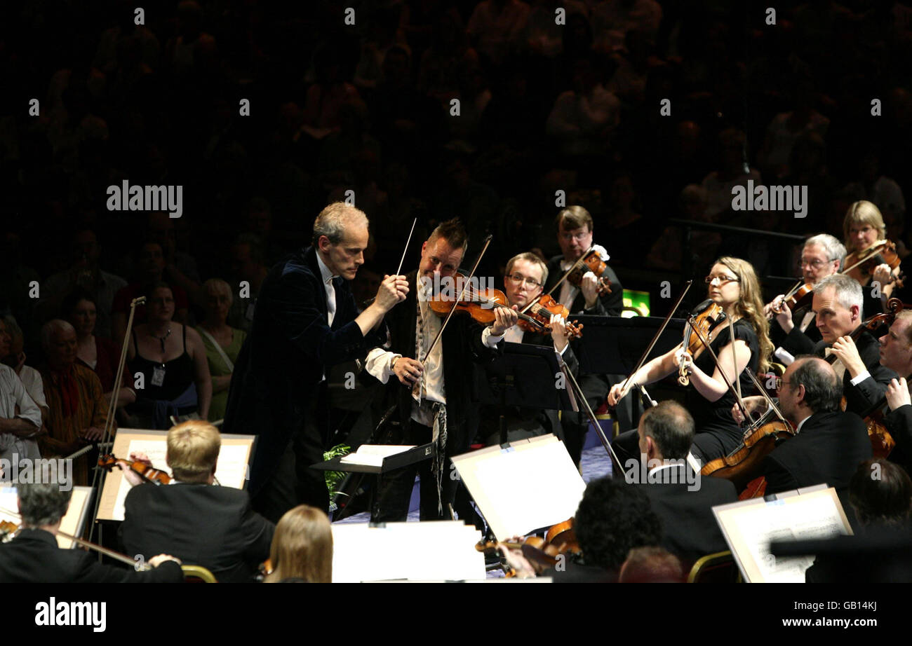 Nigel Kennedy (au centre, debout) joue avec le BBC concert Orchestra, le chef d'orchestre Paul Daniel (à gauche, debout), pendant le concert de Proms 2 à la BBC Proms, qui se déroule au Royal Albert Hall à Londres. Banque D'Images