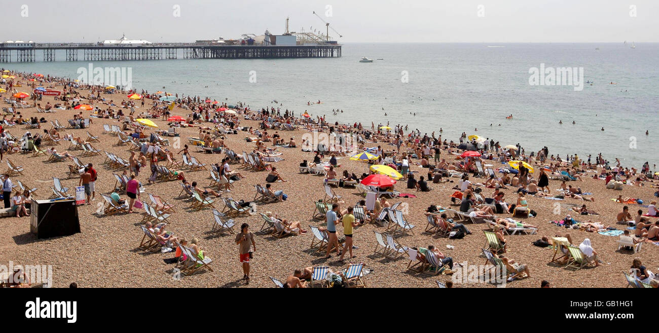 Les amateurs de plage apprécient le temps chaud sur le front de mer de Brighton. Banque D'Images