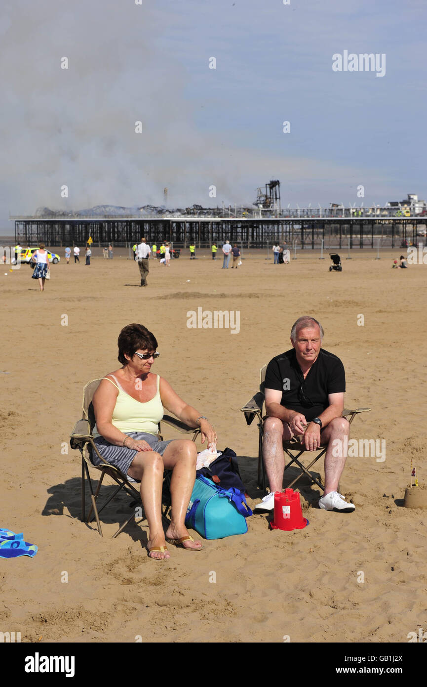 Feu de la jetée Weston-super-Mare.Les touristes apprécient le soleil sur la plage à côté du Grand Pier à Weston-super-Mare après un incendie majeur. Banque D'Images