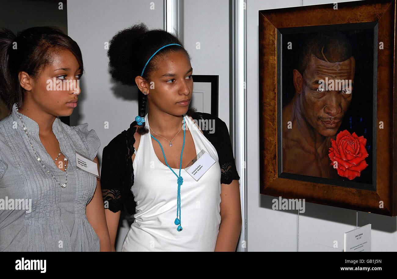 Sœurs (à gauche) Olivia, 15 ans, et Kristel, 16 ans, regardent un tableau de leur père assassiné le champion de boxe James Oyebola à l'hôtel de ville de Londres. Banque D'Images