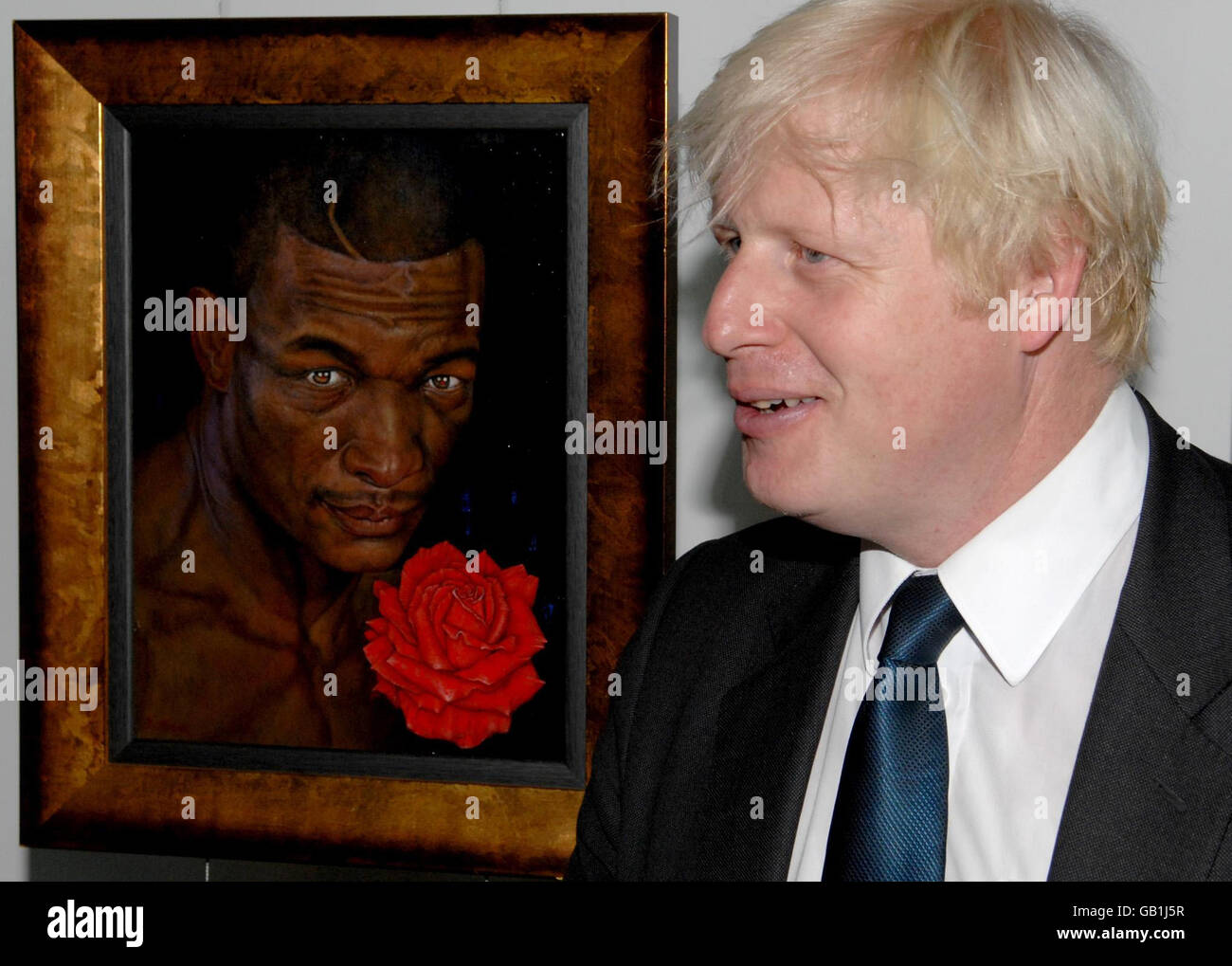 Le maire de Londres, Boris Johnson, se dresse avec un tableau du champion de boxe assassiné James Oyebola à l'hôtel de ville de Londres. Banque D'Images