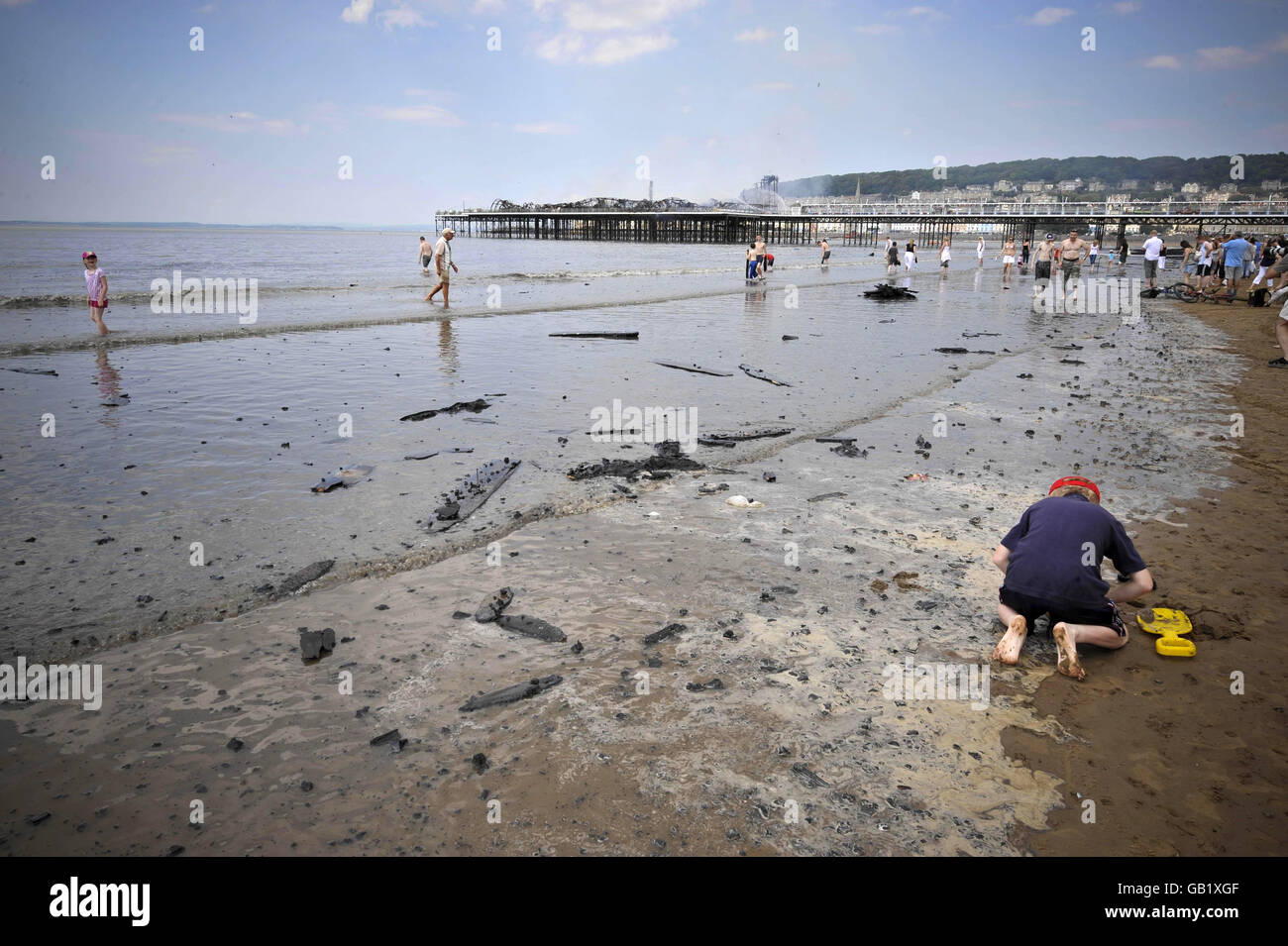 Des débris brûlés sont lavés sur la plage à côté du Grand Pier à Weston-super-Mare après un incendie majeur. Banque D'Images