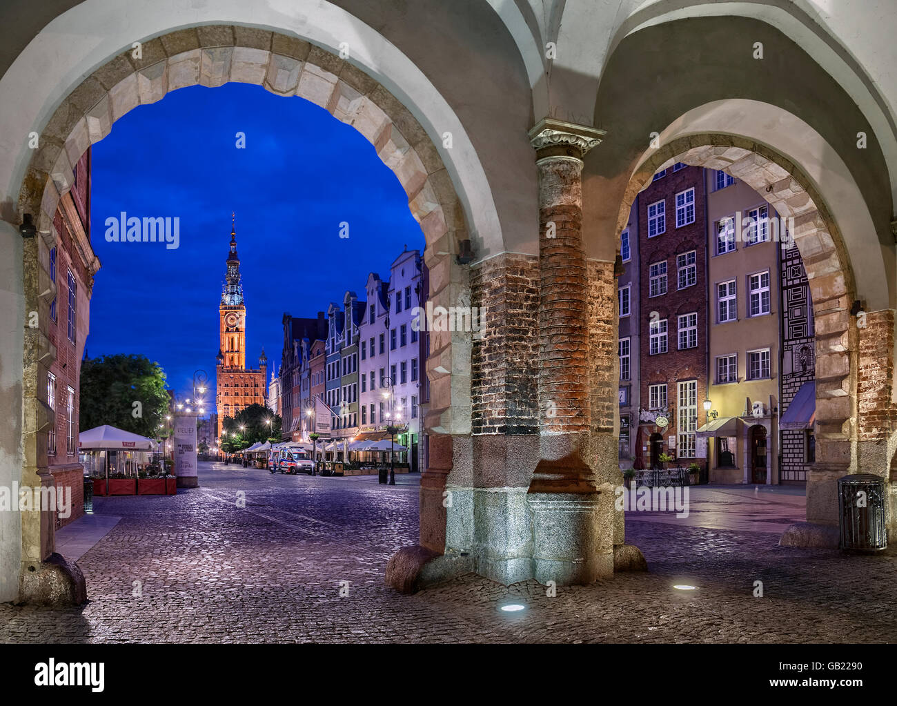 Vue à travers la porte verte ou vers les maisons Zielona Brama sur marché ou la rue Długi Targ et la tour de l'horloge de l'hôtel de ville Banque D'Images