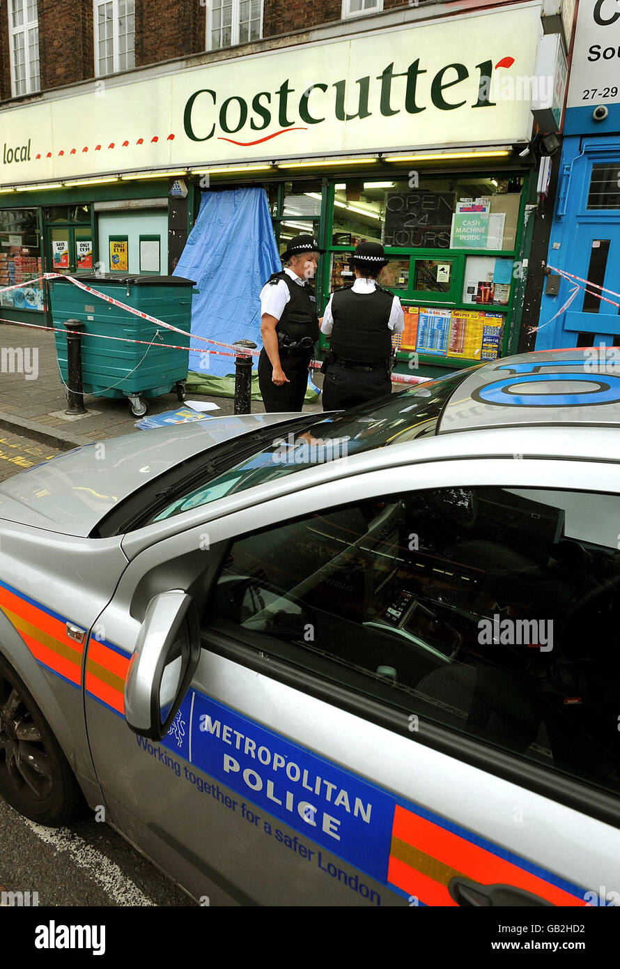 Des policiers de la police métropolitaine se tiennent devant un magasin Costcutter à Walworth, dans le sud de Londres, où un adolescent a été tué par balle après son entrée dans le dépanneur. Banque D'Images
