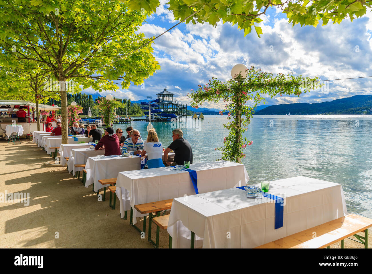 WORTHERSEE LAKE, AUTRICHE - JUN 20, 2015 : des gens assis à des tables le long de la rive du lac Worthersee en été, la fête de la bière. Banque D'Images
