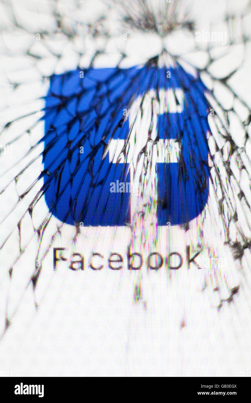 Icône Facebook vue à travers un écran apple iphone brisé UK Banque D'Images