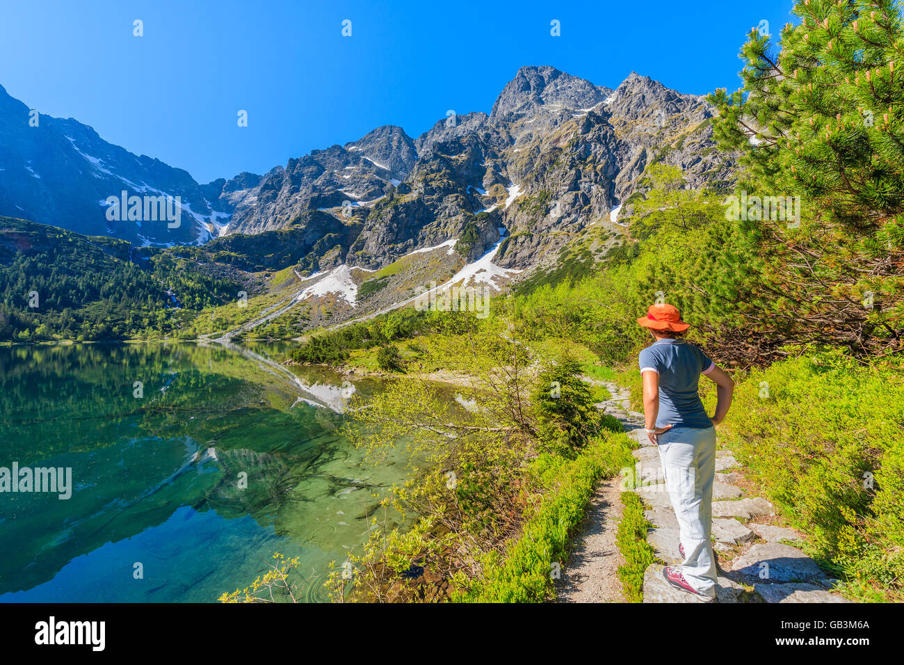 Touriste debout sur le long chemin de l'eau vert magnifique lac Morskie Oko, Tatras, Pologne Banque D'Images