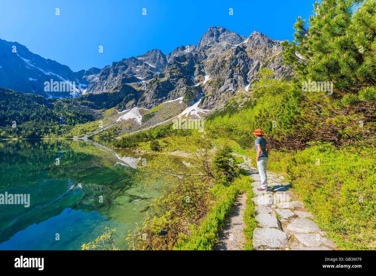 Touriste debout sur le long chemin de l'eau vert magnifique lac Morskie Oko, Tatras, Pologne Banque D'Images