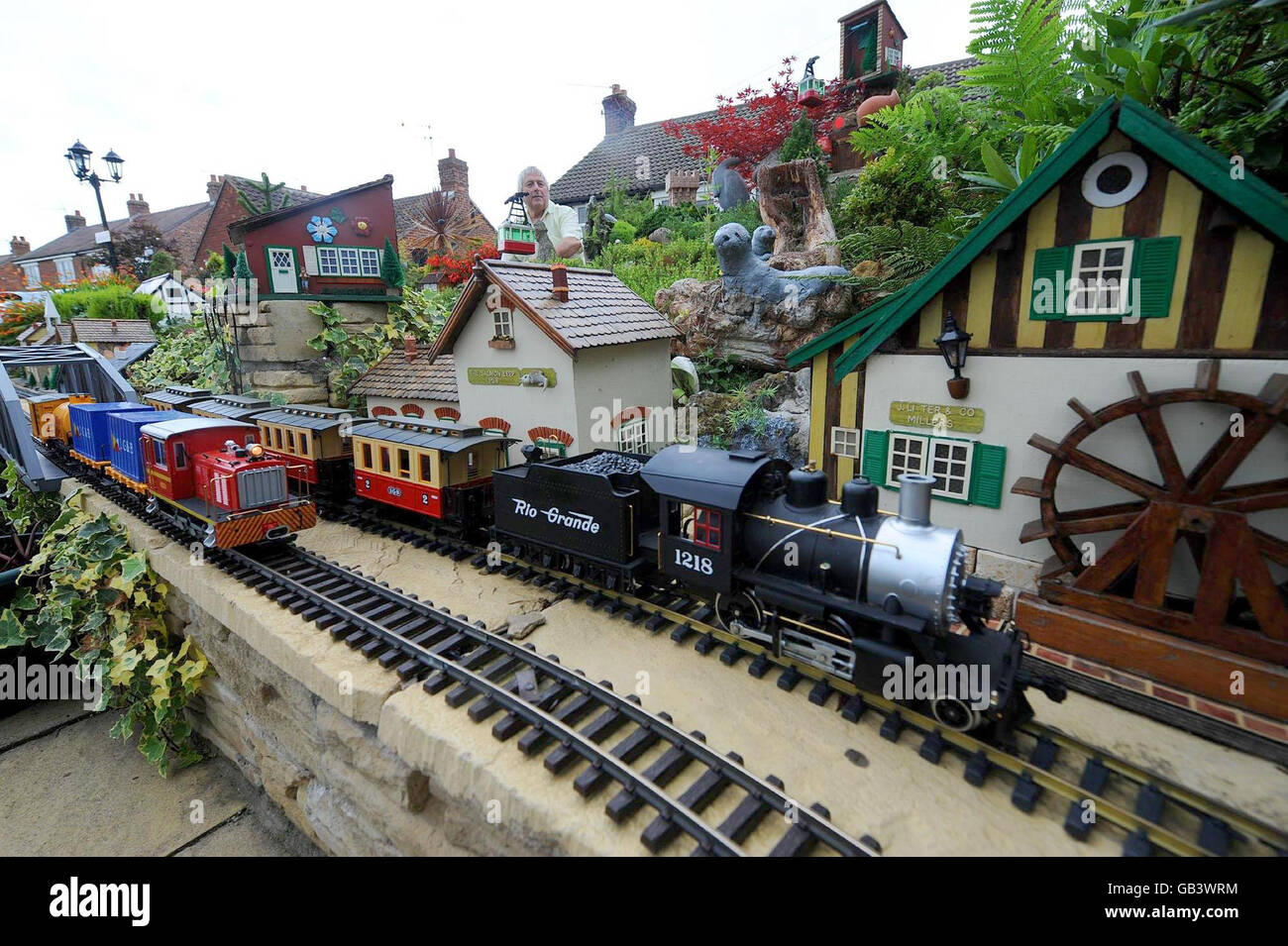 Eric Marshall (au centre), de Bagby North Yorkshire, qui a transformé son jardin avant en une ville miniature, qui comprend quatre trains de travail, des chutes d'eau et un téléphérique en état de marche. Eric a passé 3 ans à fabriquer et à concevoir son jardin et ses modèles et attire des entraîneurs quotidiens de visiteurs pour voir son travail. Banque D'Images