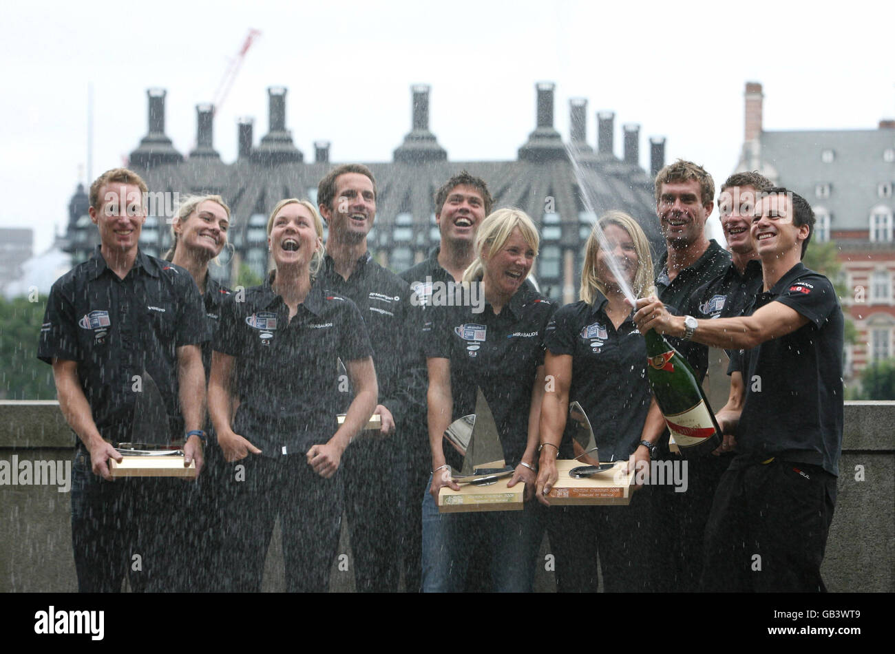 Le médaillé olympique de voile Nick Rogers (à droite) ouvre le champagne en tant que médaillés (de gauche à droite) Paul Goodison, Sarah Webb, Pippa Wilson, Ben Ainslie, Andrew Simpson, Sarah Ayton, Bryony Shaw, Iain Percy et Joe Glanfield présentent les trophées qui leur sont remis par Skandia, sponsor de l'équipe, lors d'un rendez-vous pour les marins de Team GB à l'hôtel Marriott de Londres. Banque D'Images