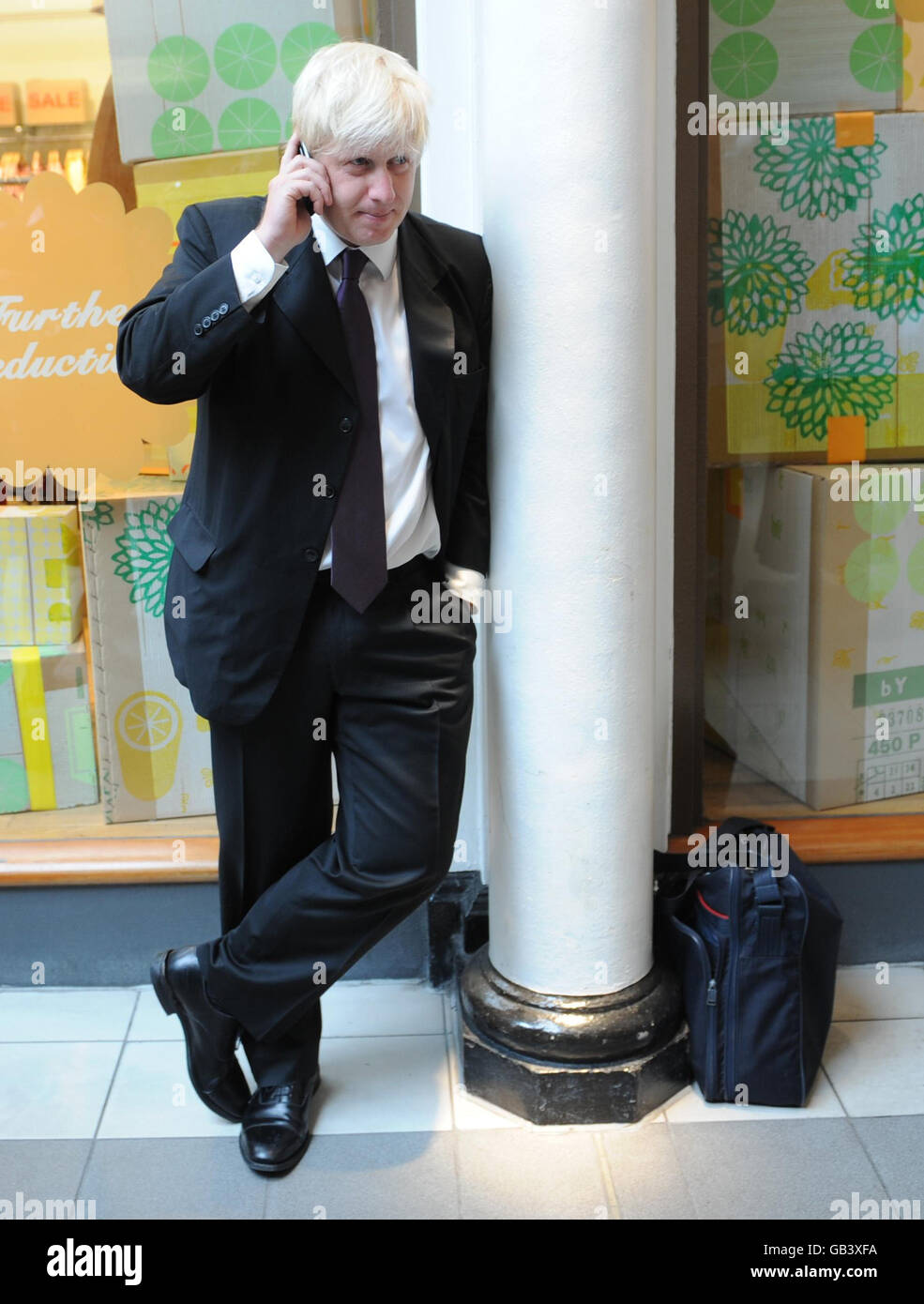 Le maire de Londres Boris Johnson prend un appel téléphonique sur Kensington High Street, dans l'ouest de Londres, où il a commencé une période de consultation sur l'avenir de la congestion charge de l'extension ouest. Banque D'Images