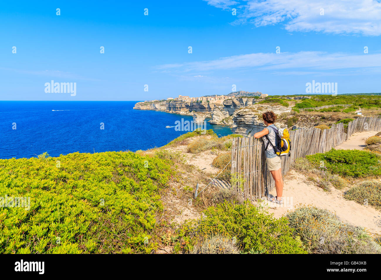 Jeune femme tourisme sentier du littoral à Bonifacio vieille ville construite sur une falaise au-dessus de la mer, Corse, France Banque D'Images