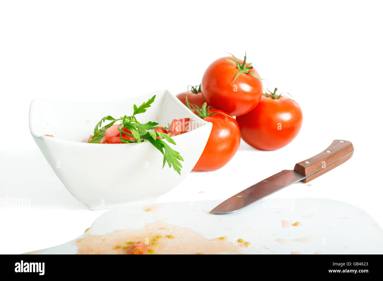 Les tomates hachées et le couteau sur une planche à découper. Focus sélectif. Banque D'Images