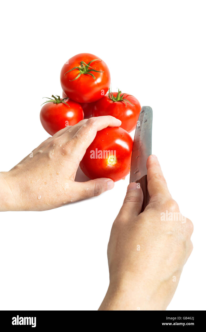 Femmes avec un couteau, couper les tomates rouges frais. Focus sélectif. Banque D'Images