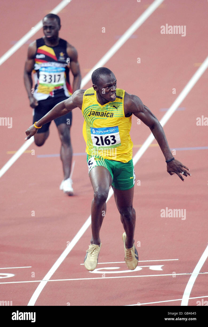 Usain Bolt de la Jamaïque atteint pour la ligne d'arrivée comme il gagne la médaille d'or de 200 m dans un temps record du monde de 19.30 secondes pour compléter un sprint double au stade national de Beijing pendant les Jeux Olympiques de Beijing 2008 en Chine. Banque D'Images